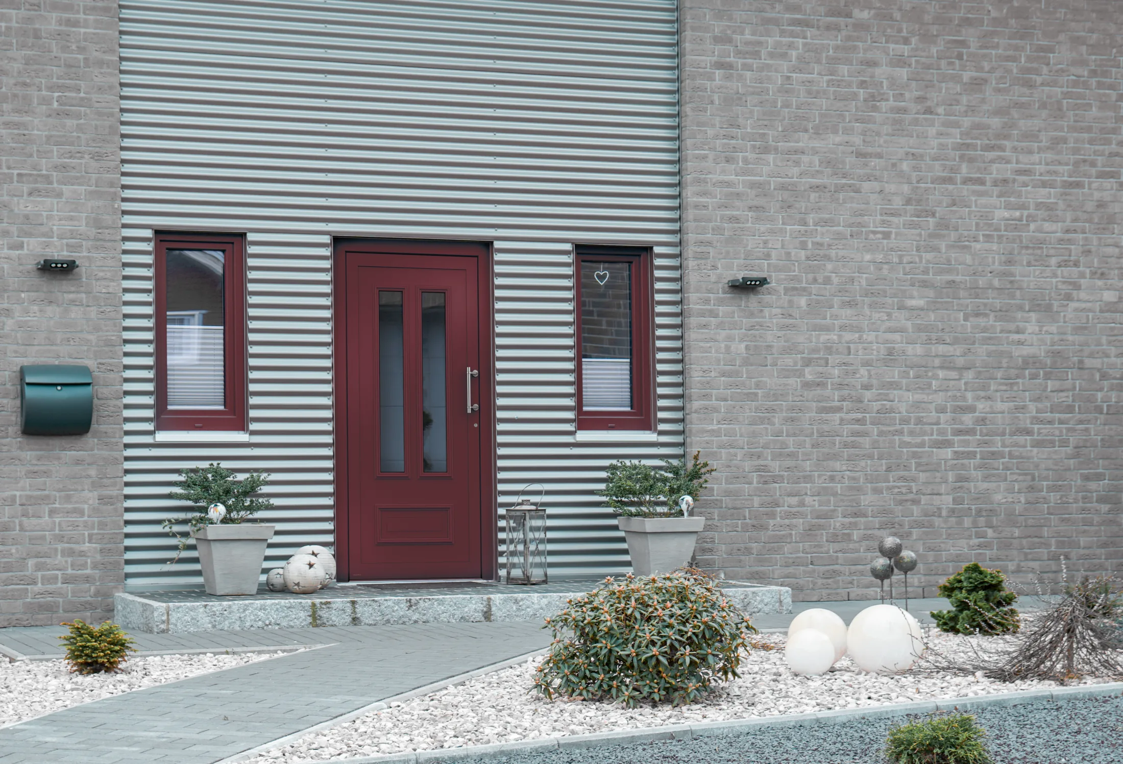 Weinrote WERU-Haustür an einem Wohnhaus